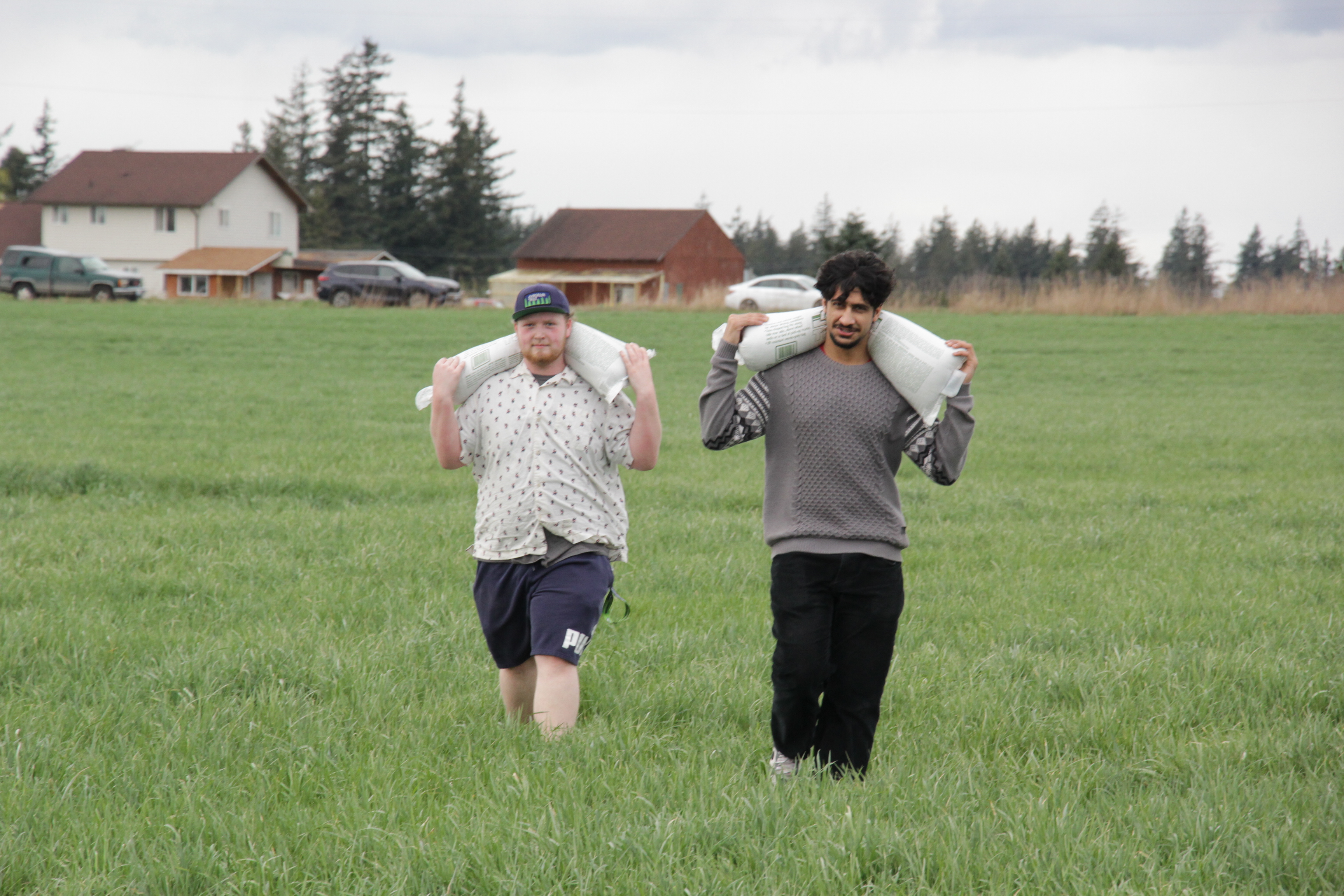 Riley and Sukhraj carrying the sandbags onto the stand